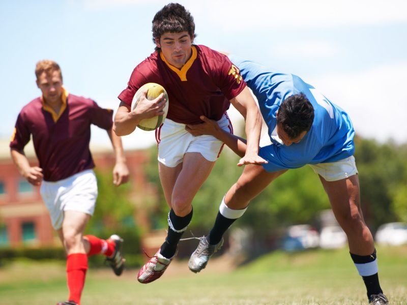 Almost there…. Full length shot of a young rugby player trying Full length shot of a young rugby player trying to avoid a tackle.